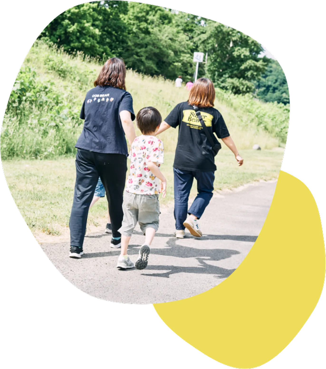 屋外で活動する親子とスタッフ